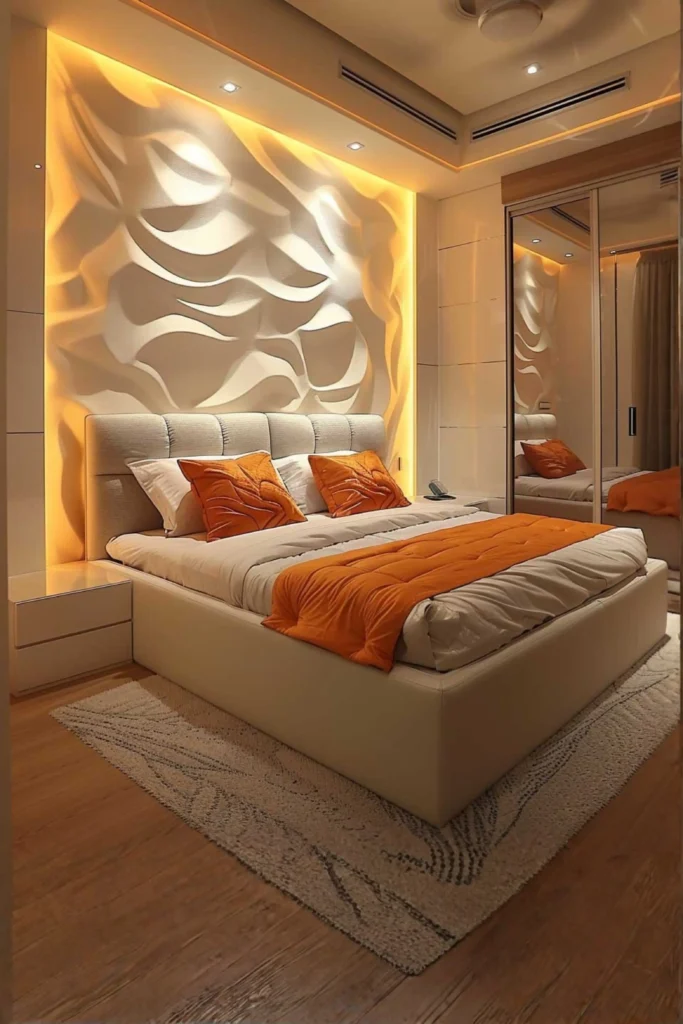 A luxury simple modern bedroom highlighting creative room wall ideas and organic textures. The focal point is a massive 3D textured accent wall behind the bed with fluid, wavy geometric patterns illuminated by warm, hidden LED backlighting. A plush cream-colored bed frame is styled with crisp white bedding, a bright orange runner, and matching orange accent pillows. To the side, a large mirrored sliding wardrobe reflects the warm ambient light and the sculpted wall details.