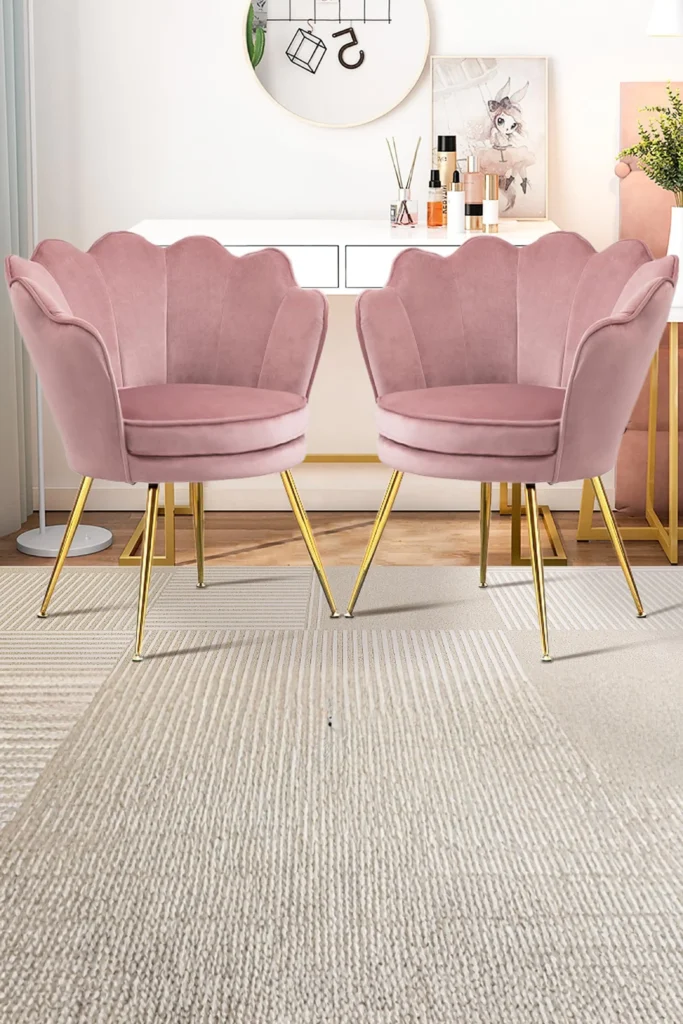 A cozy and luxurious relaxation corner highlighting elegant beauty room ideas at home. The space features a plush velvet accent chair in a soft pastel shade placed next to a sleek vanity desk layout. A small metallic side table and a fuzzy faux-fur rug on the floor complete the inviting, comfortable setup designed for unwinding.