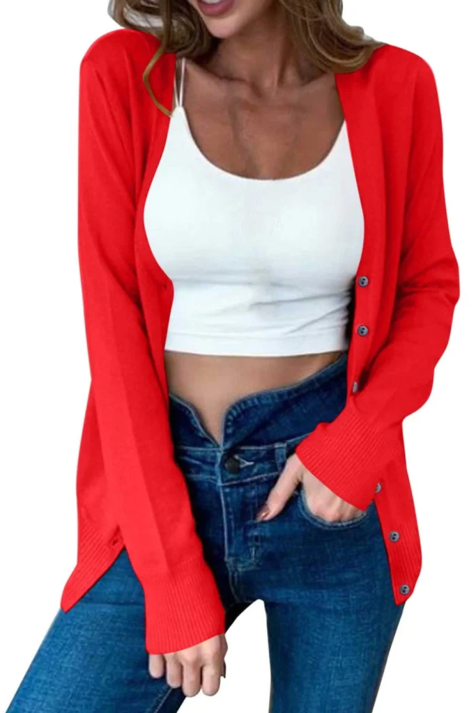 A woman showcasing a casual outfit against a plain white background. She is wearing a vibrant red soft duster cardigan with front buttons, layered over a white scoop-neck cropped tank top and paired with classic blue jeans. This look shows how a soft duster cardigan is the ultimate layering piece to add extra warmth and style to your frame.
