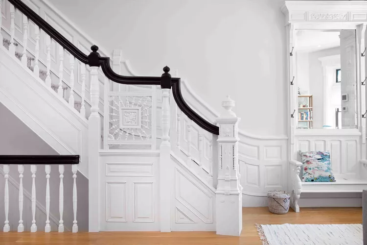 Classic white traditional wood spindle railings with a dark handrail, highlighting timeless indoor stair railing ideas.