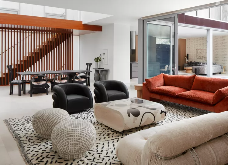 Architectural wood slat stair wall highlighting modern graystair railing ideas modern style with warm vertical timber slats in a luxury open-plan living room.